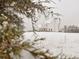 Snow-covered farmhouse features dormer windows, a porch, and a large lawn; framed by snowy foliage at 774 Forrester Cemetery Rd, Covington, GA 30014