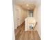 Hallway featuring wood floors leading to a staircase with white railings and modern lighting at 774 Forrester Cemetery Rd, Covington, GA 30014