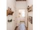 Hallway with hardwood floors, white walls, and decorative hooks and shelves adds a touch of country charm at 774 Forrester Cemetery Rd, Covington, GA 30014