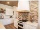 Kitchen featuring white cabinets, modern appliances, and brick accents for a chic design at 774 Forrester Cemetery Rd, Covington, GA 30014