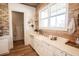 Close up of the kitchen sink featuring a farmhouse sink, wood backsplash and bright window at 774 Forrester Cemetery Rd, Covington, GA 30014