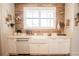 Modern farmhouse sink with marble countertop, wood backsplash, and stainless appliances at 774 Forrester Cemetery Rd, Covington, GA 30014