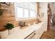 Close up of the kitchen sink featuring a farmhouse sink, wood backsplash and bright window at 774 Forrester Cemetery Rd, Covington, GA 30014