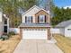 Charming two-story home with brick and siding, featuring an attached two-car garage and manicured front yard at 2365 Parkside Club Ln, Lawrenceville, GA 30044