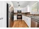 Modern kitchen features stainless steel appliances, granite countertops, and wood floors at 2365 Parkside Club Ln, Lawrenceville, GA 30044