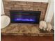 Modern electric fireplace insert with blue flame, stone surround, and display ledges at 25 Cherokee Hills Dr, Rydal, GA 30171