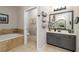 Bathroom featuring a soaking tub and vanity with gray cabinets at 25 Cherokee Hills Dr, Rydal, GA 30171