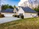 A view of the back of a charming single-story home with a pristine lawn and an attached two-car garage at 25 Cherokee Hills Dr, Rydal, GA 30171