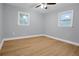 Wood flooring throughout this well-lit bedroom features two double-paned windows and a ceiling fan at 2000 Fairburn Sw Rd, Atlanta, GA 30331