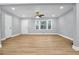 Inviting living room featuring hardwood floors, a ceiling fan, and a view of the front yard through updated windows at 2000 Fairburn Sw Rd, Atlanta, GA 30331