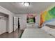 Bedroom featuring unique wall decor, hardwood floors, crib and closet space at 3071 Colonial Way # J, Atlanta, GA 30341