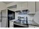 Updated kitchen showcasing granite countertops, stainless steel fridge, and range with hood at 3071 Colonial Way # J, Atlanta, GA 30341