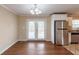 Open dining area with hardwood floors, modern lighting, and stainless steel refrigerator at 3202 Betty Cir, Decatur, GA 30032