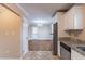 View of kitchen with granite countertops, white cabinets, stainless steel refrigerator, and view into dining area at 3202 Betty Cir, Decatur, GA 30032