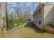 Backyard featuring a grassy area, mature trees, and the exterior of a brick home at 3465 Tulip Dr, Decatur, GA 30032