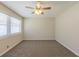Neutral-toned bedroom with plush carpeting, a ceiling fan, and a large window allowing ample sunlight at 3465 Tulip Dr, Decatur, GA 30032