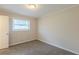 Well-lit bedroom with carpeting, window with blinds, paneled walls, and a door leading to the rest of the home at 3465 Tulip Dr, Decatur, GA 30032