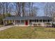 Charming single-story home with a white brick exterior, covered carport, well-maintained lawn, and bright red front door at 3465 Tulip Dr, Decatur, GA 30032