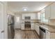 Open-concept kitchen with granite countertops, stainless steel appliances, and ample cabinet space, leading to backyard access at 3465 Tulip Dr, Decatur, GA 30032
