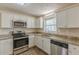 Modern kitchen with granite countertops, stainless steel appliances, white cabinets, and updated lighting at 3465 Tulip Dr, Decatur, GA 30032