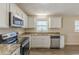 Well-lit kitchen featuring granite counters, updated appliances, ample cabinet space, and stylish flooring at 3465 Tulip Dr, Decatur, GA 30032