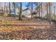 Home's wooded backyard with mature trees, wooden fence, and a deck visible from the back of the house at 7065 Walnut Mill Ct, Cumming, GA 30040