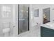 Well-lit bathroom with a glass shower, tub, and marble floors, offering a spa-like experience at 7065 Walnut Mill Ct, Cumming, GA 30040