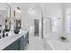 Bright bathroom featuring dual sinks, marble floors, a soaking tub, and a walk-in closet at 7065 Walnut Mill Ct, Cumming, GA 30040