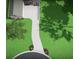 Aerial view of the property featuring lush green grass, landscaping, circular driveway and modern home at 7065 Walnut Mill Ct, Cumming, GA 30040