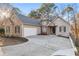 Charming stucco home with stone accents, driveway, and a two-car garage at 7065 Walnut Mill Ct, Cumming, GA 30040