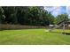 Lush backyard featuring a large lawn, privacy fence, and deck stairs at 838 Natchez Valley Trce, Grayson, GA 30017