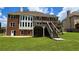 Large brick home featuring an expansive lawn and second-story deck with stairs at 838 Natchez Valley Trce, Grayson, GA 30017