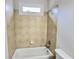 Standard white bathtub with tile surround in a well-lit bathroom at 838 Natchez Valley Trce, Grayson, GA 30017
