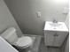 Compact bathroom featuring modern sink, white cabinet and toilet on marble-style tile at 838 Natchez Valley Trce, Grayson, GA 30017