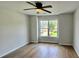 Cozy bedroom with wood floors, ceiling fan, and bright window with neighborhood view at 838 Natchez Valley Trce, Grayson, GA 30017