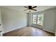 Bright bedroom with hardwood floors, ceiling fan, and large window overlooking neighborhood at 838 Natchez Valley Trce, Grayson, GA 30017
