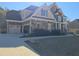 Beautiful brick and stone home with a manicured front lawn and three car garage at 838 Natchez Valley Trce, Grayson, GA 30017