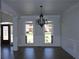 Bright living room with detailed trim, chandelier, arched windows that offer a neighborhood view at 838 Natchez Valley Trce, Grayson, GA 30017