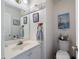 Cozy bathroom with single sink vanity, decorative wall art, and classic white fixtures at 2000 Spicers Ln, Woodstock, GA 30189