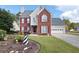 Charming two-story brick home featuring a well-manicured lawn, red shutters and attached garage at 2000 Spicers Ln, Woodstock, GA 30189