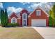 Charming red brick two-story home with landscaped front yard and attached two car garage at 283 Double Gate Way, Sugar Hill, GA 30518