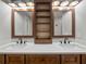 Bright bathroom featuring double vanity with modern faucets, wood cabinets, and modern light fixtures at 3121 Cox Cemetery Rd, Social Circle, GA 30025