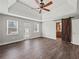 Spacious bedroom featuring hardwood floors, a tray ceiling, a sliding barn door, and access to the deck at 3121 Cox Cemetery Rd, Social Circle, GA 30025