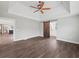Open main bedroom featuring hardwood floors, tray ceiling, fan, and views to kitchen area at 3121 Cox Cemetery Rd, Social Circle, GA 30025