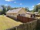 Backyard view featuring a cozy patio, privacy fence, shed, and lush green lawn, perfect for outdoor relaxation at 2190 Leatherstone Dr, Powder Springs, GA 30127