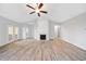 Bright living room featuring vaulted ceiling, fireplace, ceiling fan, and light wood flooring at 2190 Leatherstone Dr, Powder Springs, GA 30127
