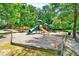 Community playground with slides and play structures nestled among mature trees at 2190 Leatherstone Dr, Powder Springs, GA 30127