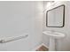 Simple powder room with pedestal sink, modern mirror, and a convenient grab bar at 2190 Leatherstone Dr, Powder Springs, GA 30127