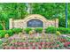 Stone monument sign for Robinson Glen neighborhood surrounded by flowering shrubs, greenery, and trees at 2190 Leatherstone Dr, Powder Springs, GA 30127