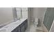 Bright bathroom features marble countertops, grey cabinets and tile flooring next to the toilet and stand up shower at 4252 Parkview Ct, Stone Mountain, GA 30083